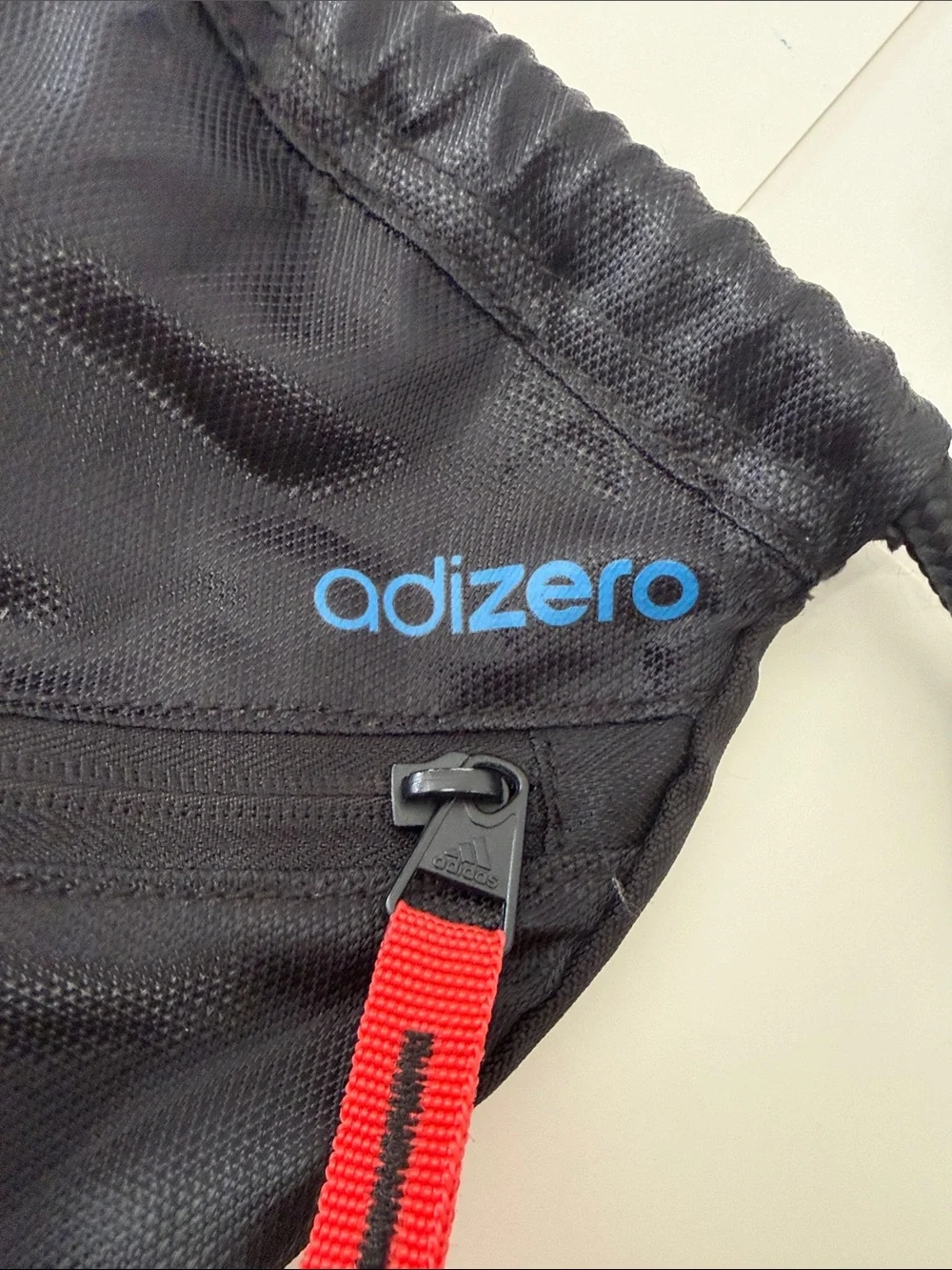 adidas Black Drawstring Backpack with Blue Stripes and Red Accents